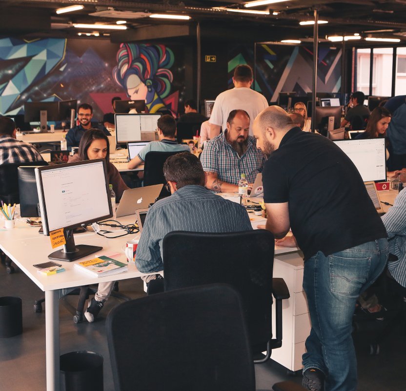 Un equipo de profesionales de Azion, alineados en una sala de reuniones, discutiendo estrategias comerciales y colaborando en un entorno de trabajo moderno y dinámico.