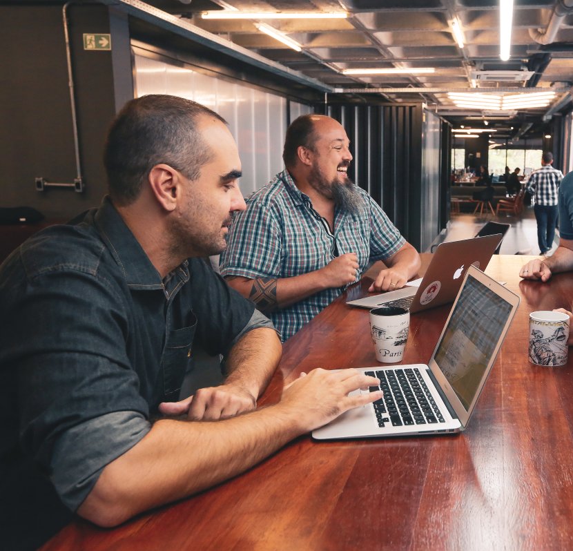 Un grupo de empleados de Azion colaborando en un entorno de oficina amplio y luminoso con una decoración moderna y energía vibrante.